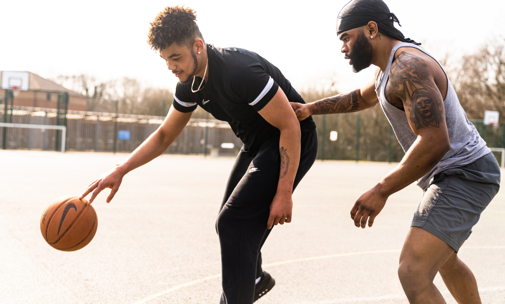 two students playing basketball