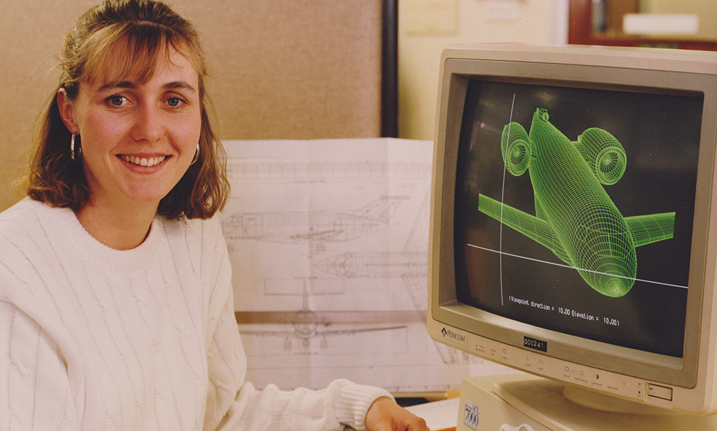 Female student seated at computer with aeronautical image on 1970s computer