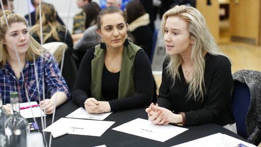 Women talking at table during conference
