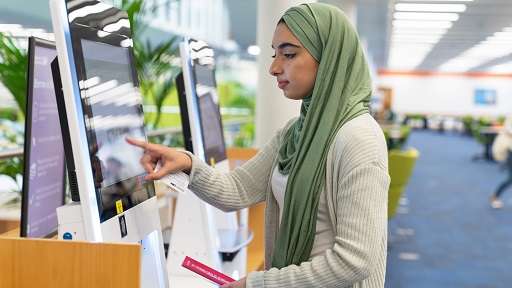 A woman touching a computer screen in the Learning Resource Centre