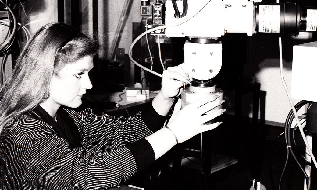 Female student using engineering equipment in 1980