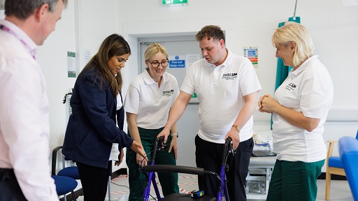 Two students teaching another student how to use a walking aid