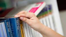 Student looking through library shelves