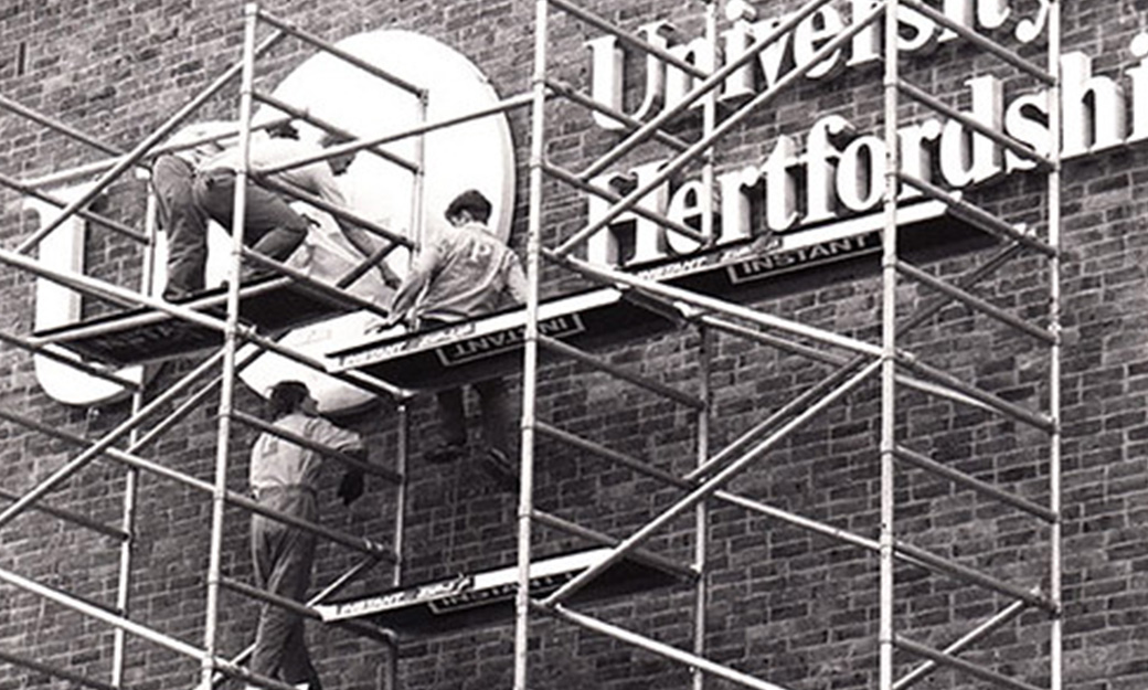 University sign being erected on the side of a building